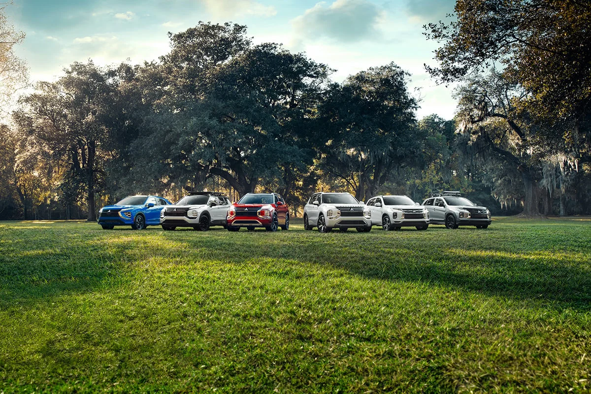 Six Mitsubishi SUVs parked in a field